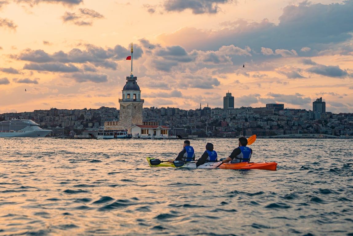 A guest in a life jacket smiling mid-paddle on the Bosphorus