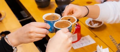 Guests holding small cups of Turkish coffee at an Istanbul coffee and fortune-telling workshop