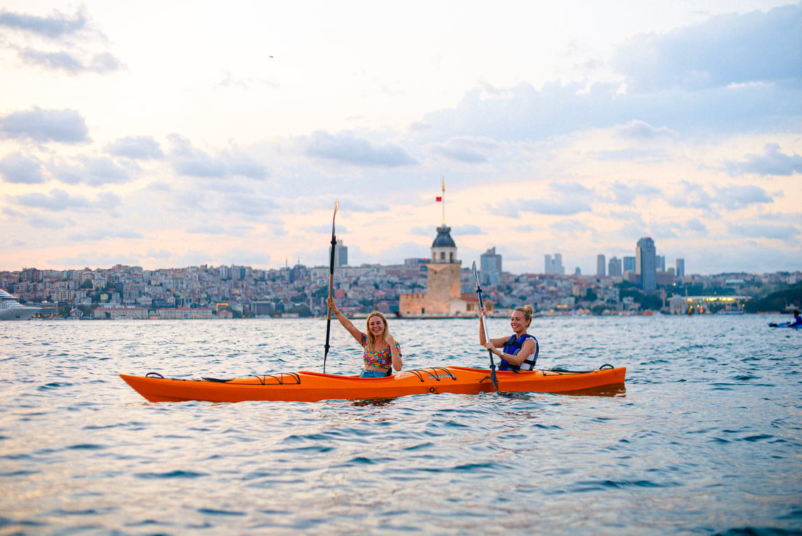 A canoe on the Bosphorus at water level with the Maiden's Tower and the Istanbul skyline behind