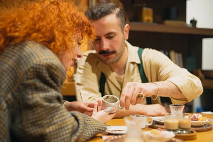 Guest brewing Turkish coffee in a copper cezve at a Turkish coffee workshop in Istanbul