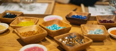 Bowls of colorful glass beads and tiles laid out for a mosaic lamp workshop in Istanbul