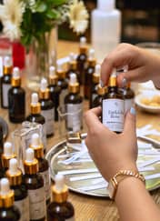 Selecting fragrance essences from amber bottles at an Istanbul perfume-making workshop