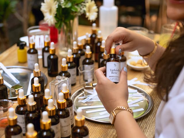 Selecting fragrance essences from amber bottles at an Istanbul perfume-making workshop