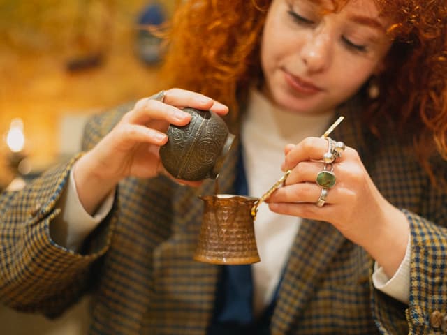 Learning how to make Turkish coffee by measuring ground coffee into a cezve at an Istanbul coffee class