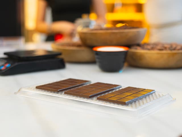 Molded chocolate bars beside bowls of cocoa beans at a chocolate-making workshop in Istanbul.