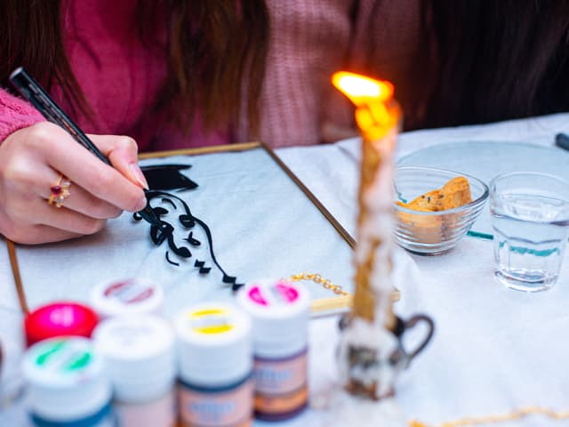 Painting a black ink design at an Istanbul brass-framed calligraphy workshop