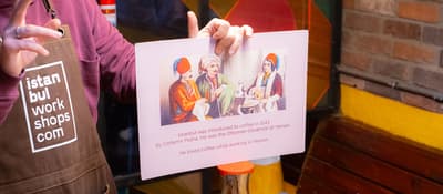 Instructor shares the history of Turkish coffee on a card at a coffee workshop in Istanbul