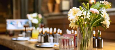 Perfume-making station with essence bottles and fresh flowers on a wooden bar in Istanbul