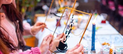 Guests holding brass-framed calligraphy artworks at an Istanbul calligraphy workshop